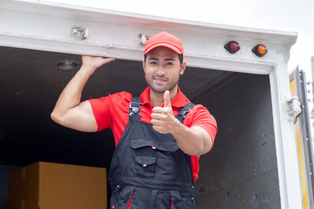 Uśmiechnięty pracownik firmy relokacyjnej podczas przenoszenia firmy